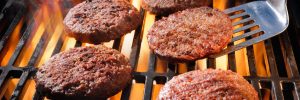Beef hamburger patties sizzling on the barbecue